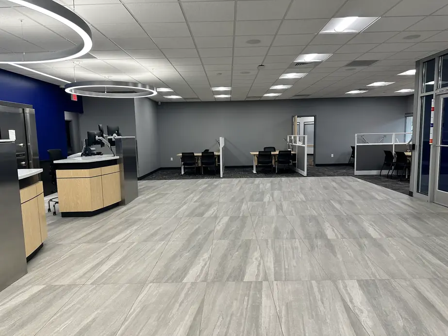 A large office lobby with a long run of clean grey tile floor